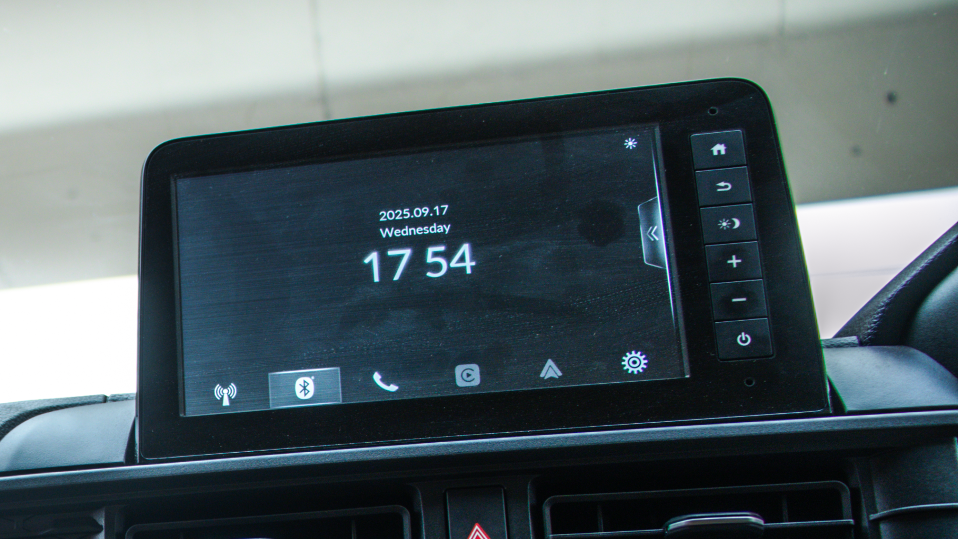 Honda Amaze's dashboard infotainment screen displaying the date and time, alongside physical control buttons on the right bezel