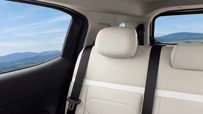 Citroen Aircross Comfort Edition interior cabin rear seats with premium white leatherette upholstery, black seatbelts, and a scenic mountain view through the window.
