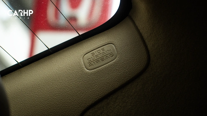 Close-up of a beige Honda Amaze interior pillar featuring embossed "SIDE CURTAIN AIRBAG" text