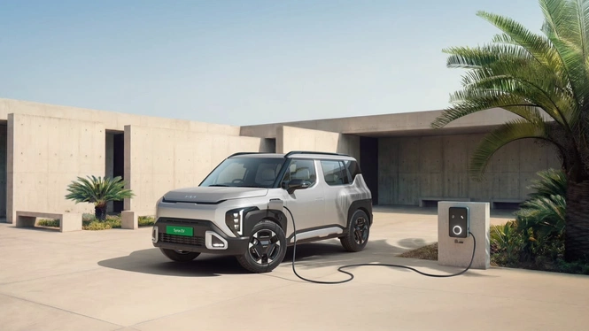 Kia Syros EV charging at an EV charging station, with charging cable attached.